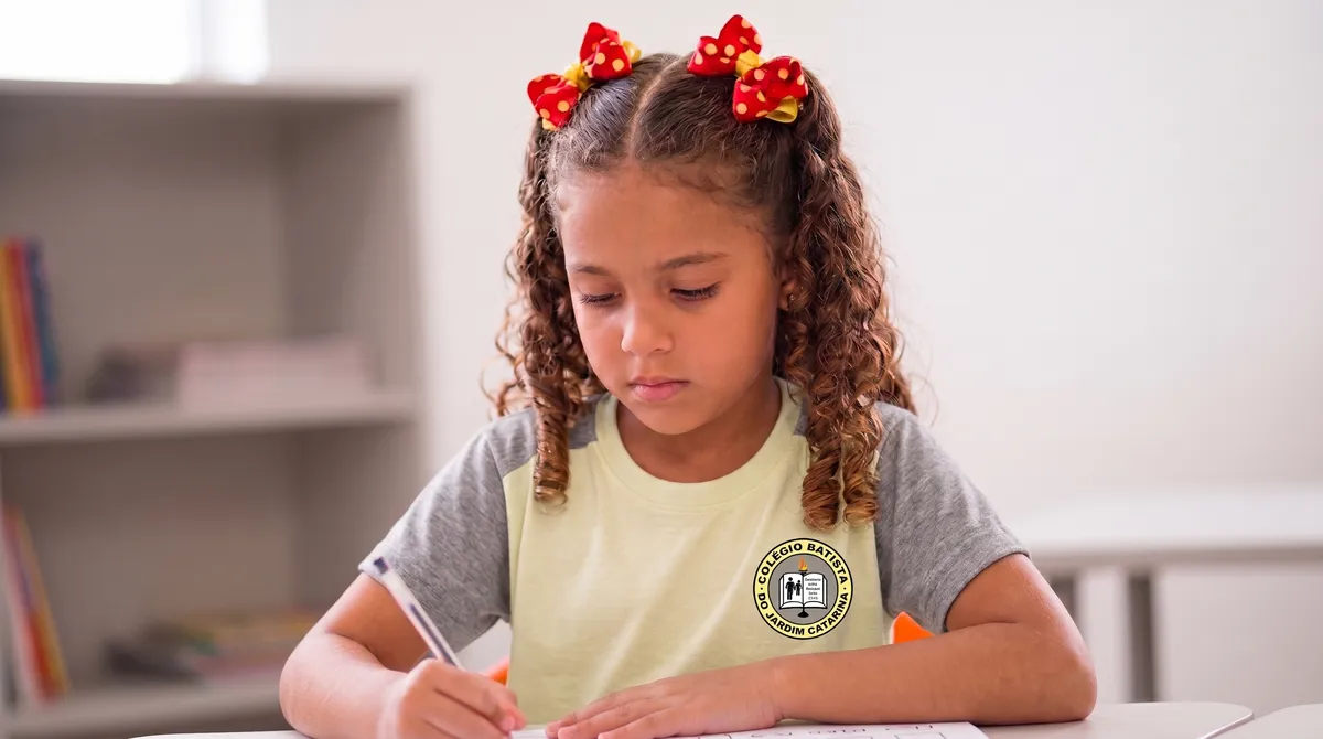 Aluna da Educação Infantil escrevendo em sala de aula