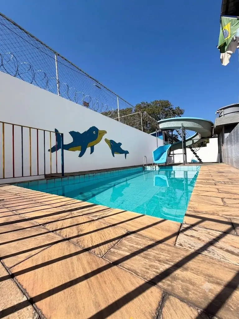 Piscina do colégio com toboágua e painel de golfinhos